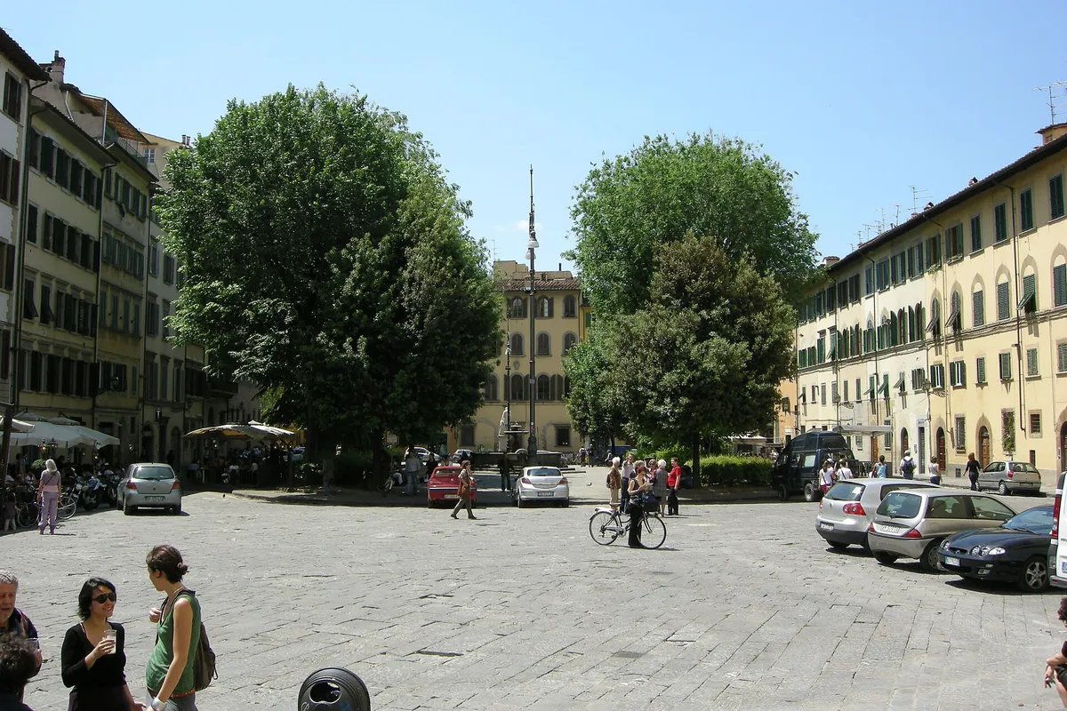 Piazza Santo Spirito i Firenze, en åben brostensbelagt plads med træer og bygninger i varme farver på begge sider